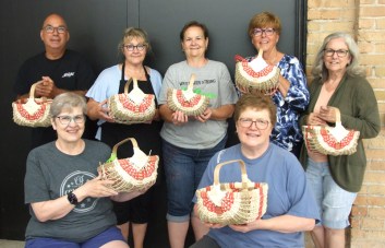 Students holding up the baskets woven in this workshop.