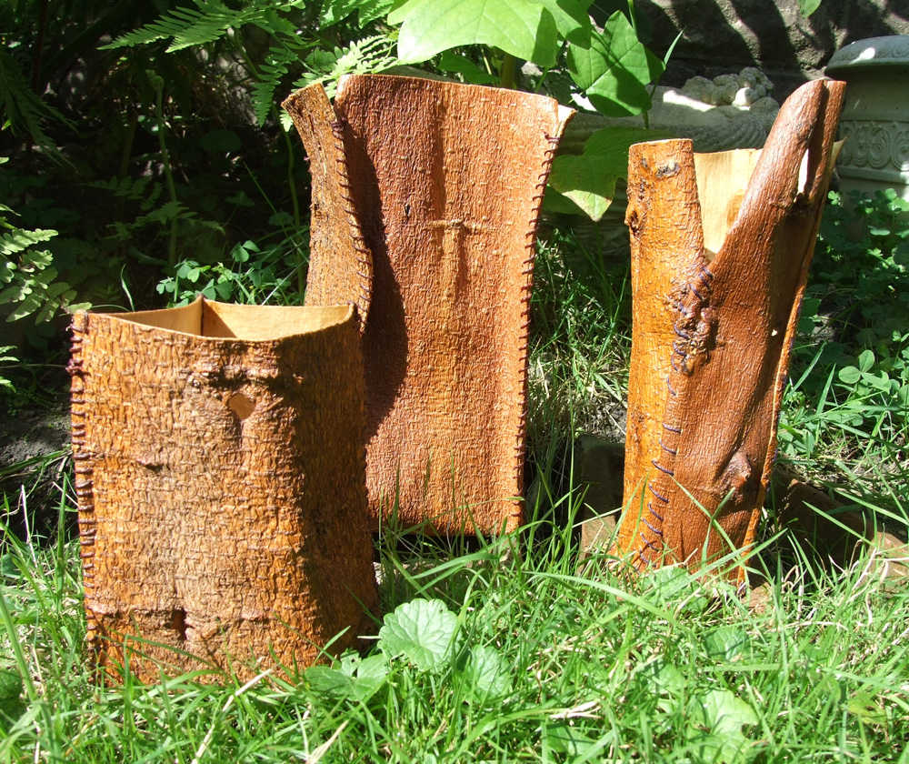 Three rustic mulberry bark vases. The panels of bark are sewn together using waxed linen. I used lilac and brown waxed linen.